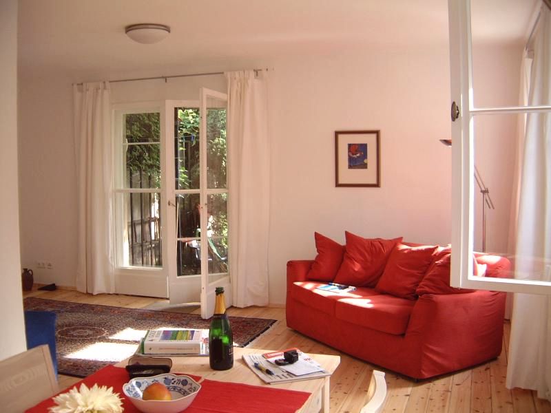 das rote Sofa im Ferienhaus Berlin-Cottage lädt zum Kuscheln ein